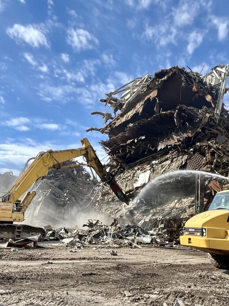 Excavator loading demolition debris into an articulated haul truck