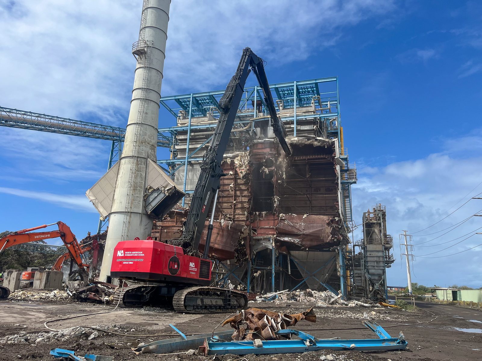 High-reach excavator demolishing the boiler structure at the AES Hawaii power plant