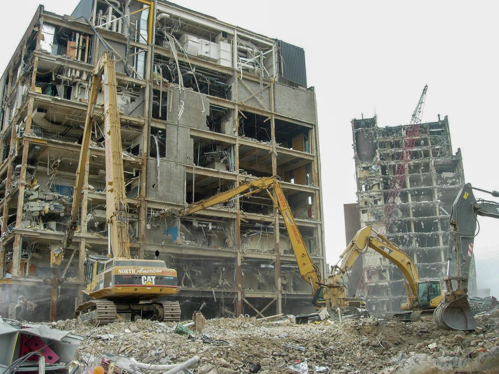 Excavators demolishing multistory laboratory buildings at a pharmaceutical campus